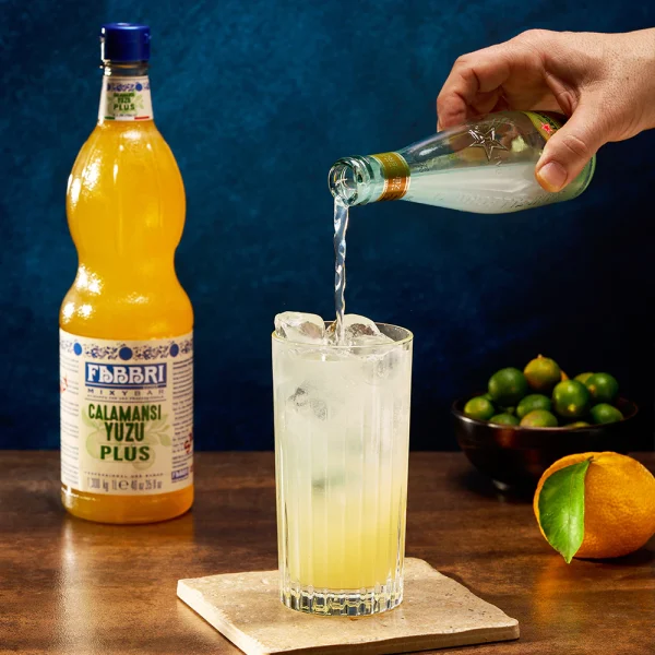 Drink cítrico preparado com xarope Mixybar Plus Calamansi Yuzu Fabbri, servido com gelo e apresentação refrescante.