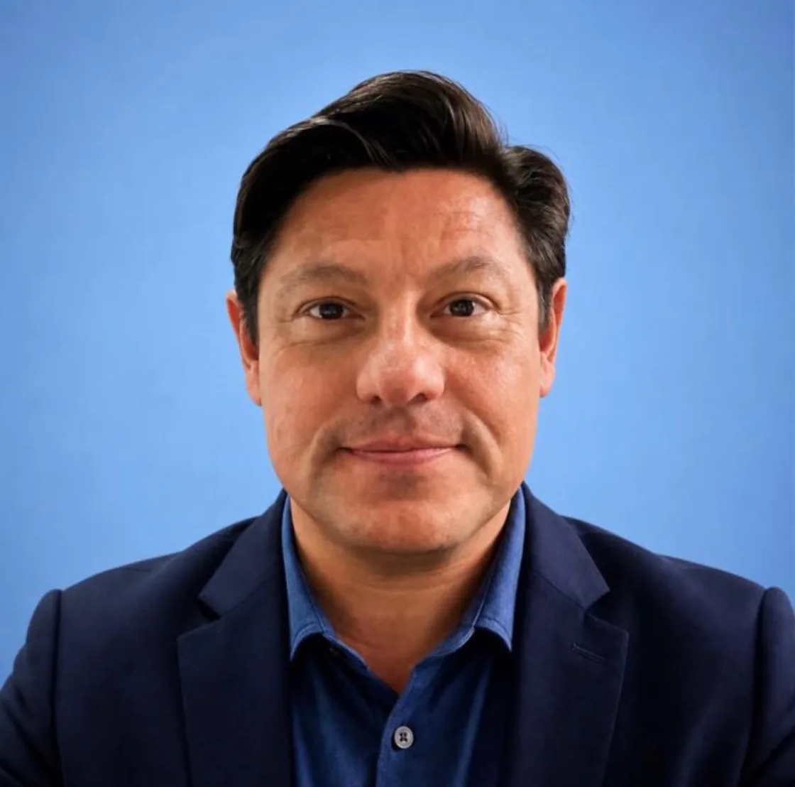 Retrato de Mauricio, gerente geral da GETU Shopping, diante de um fundo azul